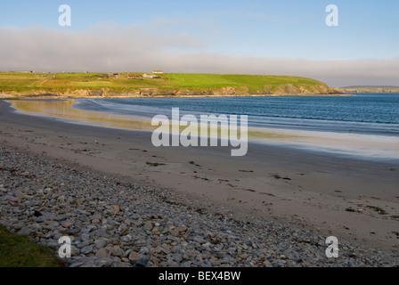 landscape view of tresta beach with sun on the water and shade on the beach on Fetlar of the Shetland islands Stock Photo