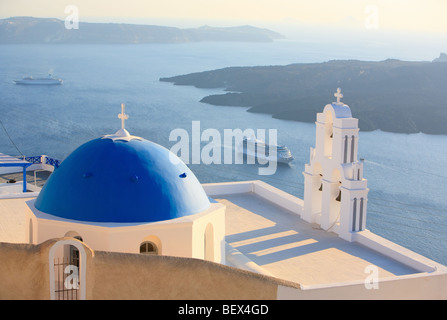 Blue domed church in Imerovigli overlooks spectacular caldera surrounding beautiful island of Santorini, Greece Stock Photo