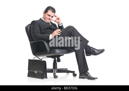 Young pensive businessman sitting on a chair Stock Photo