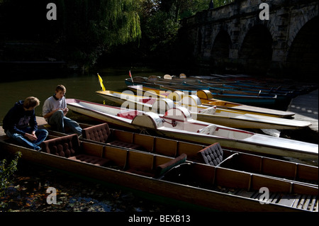 Moored punts and paddle boats for hire on the River Thames at Magdalen Bridge Oxford
