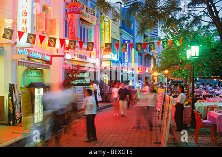 Quayside seafood restaurants and bars on Singapore River with lamplights and outdoor tables at night Stock Photo