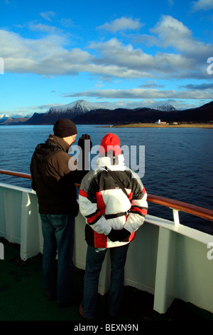couple wearing warm arctic clothing admiring the norwegian coastline from ms nordkapp
