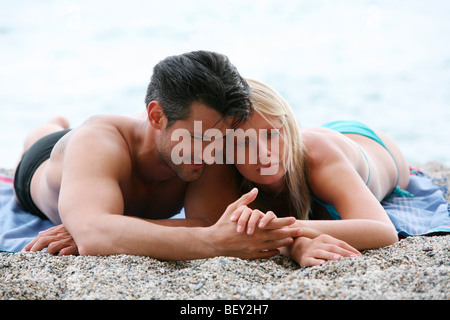 young couple lying on beach Stock Photo
