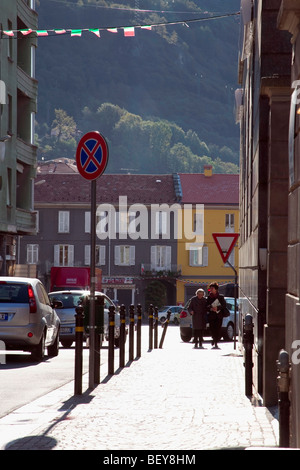 backs to the mid-morning sun, the people seem to have halos and the shadows are long; it is a street in the village center Stock Photo