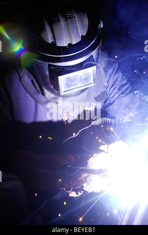 A welder works on the hull of a steel ship in a Glasgow shipyard. Stock Photo