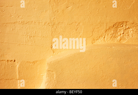Detail of wall in warm light where four different surfaces join which have been roughly rendered then all painted cream Stock Photo
