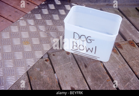 Wooden slatted flooring with aluminium sloping entrance ramp and plastic box labelled in felt-tip pen Dog Bowl Stock Photo