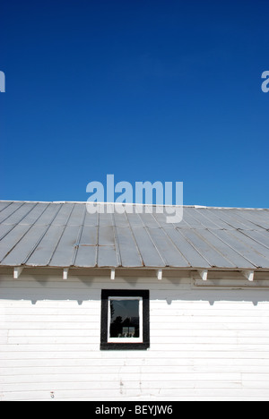 White barn under blue skies Stock Photo