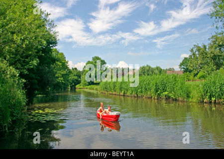 2 teenage boys in a rubber dinghy on a river Stock Photo