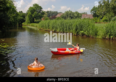 teenage boy in a rubber dinghy on a river Stock Photo