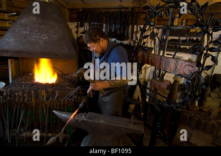 A village blacksmith forging a new sign for Ditchling in Sussex Stock Photo