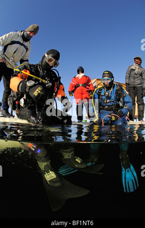 ice diving, split shot from ice divers and safty rope, White Sea, Russia Stock Photo