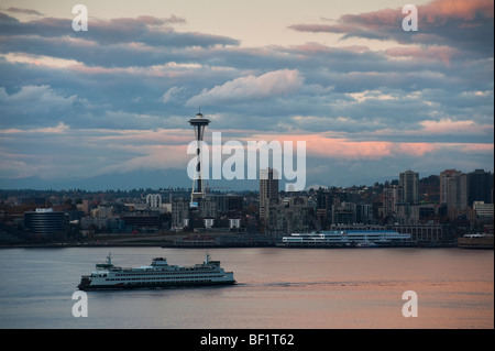 A dramatically lit view of the Seattle Space Needle and a ferry boat crossing Elliott Bay to Bainbridge Island. Washington State Stock Photo