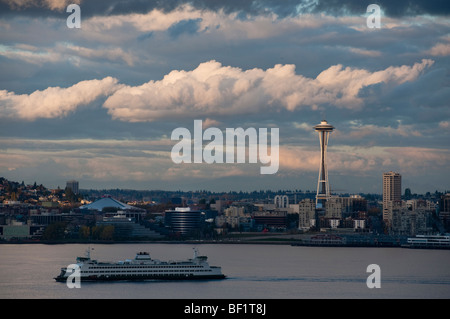 A dramatically lit view of the Seattle Space Needle and a ferry boat crossing Elliott Bay to Bainbridge Island. Washington State Stock Photo
