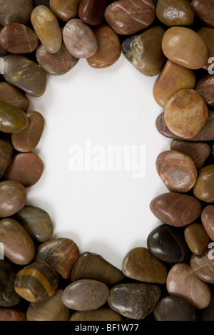 A photograph of polished pebbles with white space in centre of the image. Stock Photo