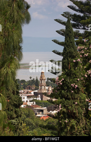 A view looking through mountain trees down at the baroque San Andres parish church on the shore of Lake Chapala, Ajijic, Mexico. Stock Photo