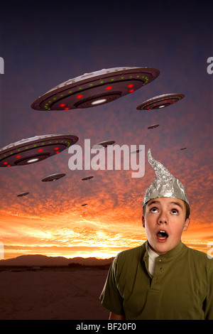 A boy wearing a tin-foil hat observes a squadron of UFOs.