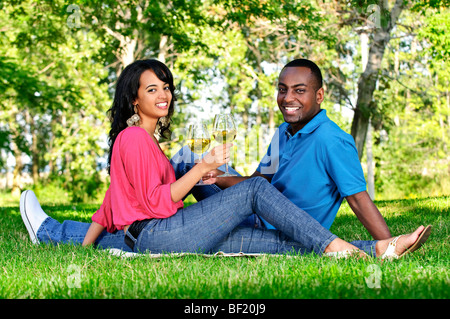 Young romantic couple celebrating with wine in summer park Stock Photo