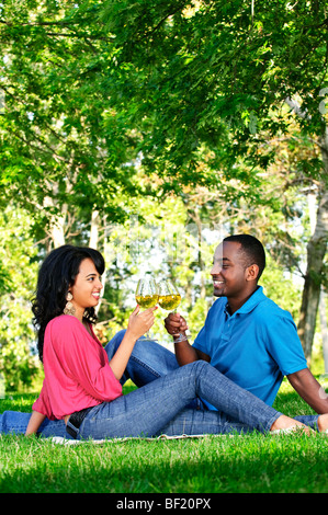 Young romantic couple celebrating with wine in summer park Stock Photo