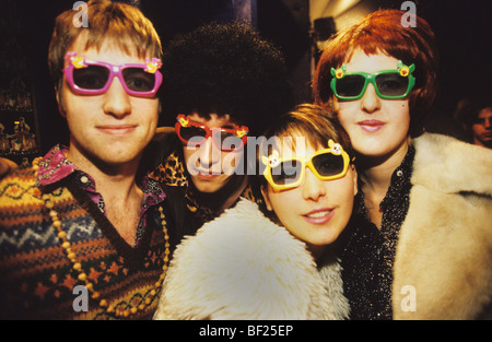 A group of club goers posing for a photo at Scandal night club, during Seventies night. London, England, Great Britain Stock Photo