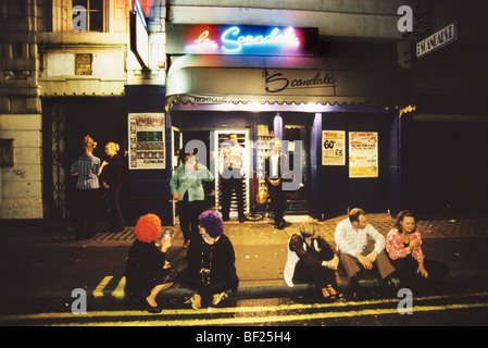 Sitting outside on pavement, Scandal night club, Seventies night. London, England, Stock Photo