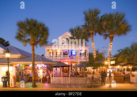 People sitting on the illuminated terrace of a bar in the evening, Duval Street, Key West, Florida Keys, Florida, USA Stock Photo