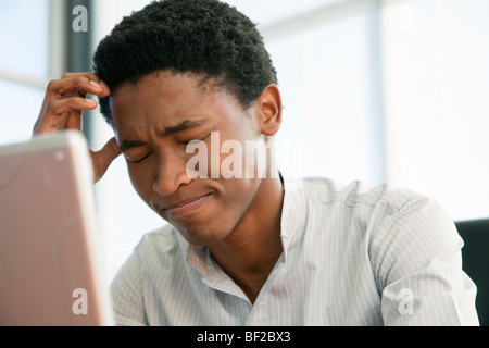 Businessman sitting at his computer looking stressed, Cape Town, Western Cape Province, South Africa Stock Photo