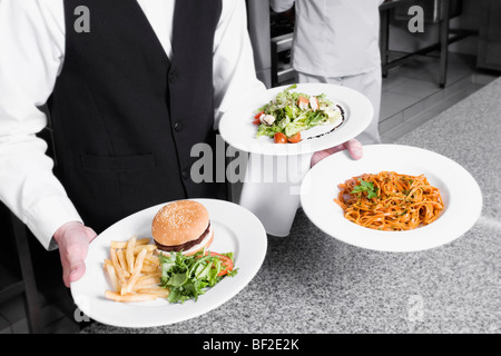 Waiter holding plates of foods Stock Photo