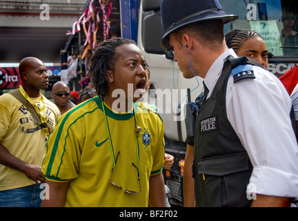Young man argues with police officer at Notting Hill Carnival Stock Photo