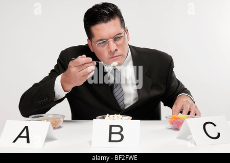 Businessman tasting food samples Stock Photo