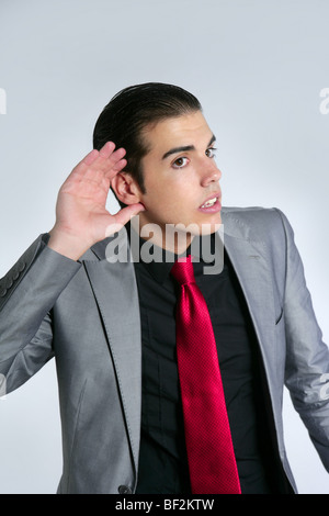 Businessman with hand in ear as a deafness sign gesture Stock Photo