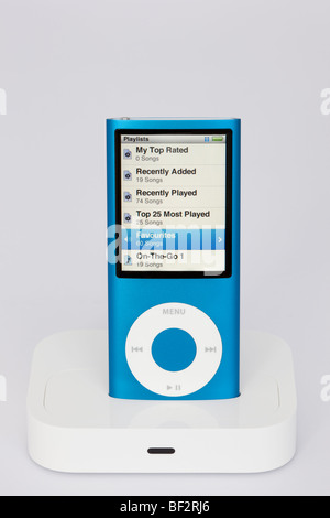 Blue Apple iPod Nano 4G in a dock with playlist view on screen. Stock Photo