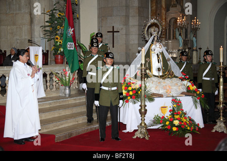 Police guard and the Virgen de Copacabana during mass for the police and Republic on 6th August Independence Day, La Paz cathedral, Bolivia Stock Photo