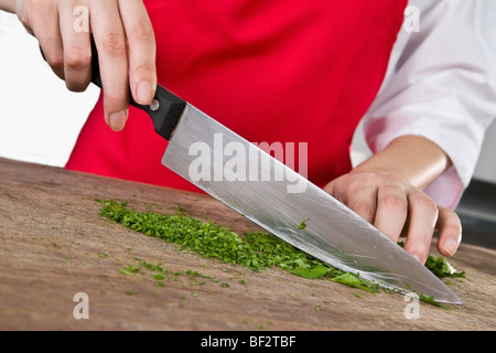 Premium Photo  Chef chopping parsley with knife on a wooden board close up