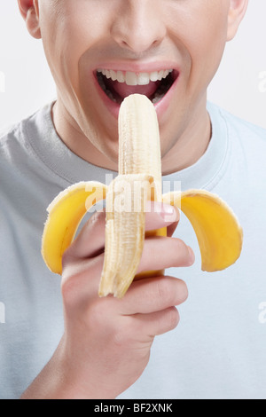 Close-up of a man eating a banana Stock Photo