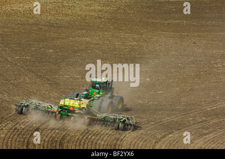 A John Deere tractor and air seeder planting garbanzo beans (chick peas) in the rolling hills of the Palouse / Washington, USA. Stock Photo