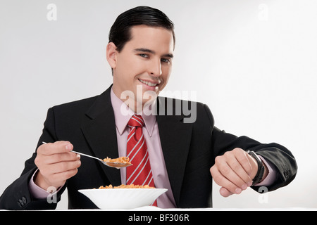 Businessman checking the time at breakfast table Stock Photo