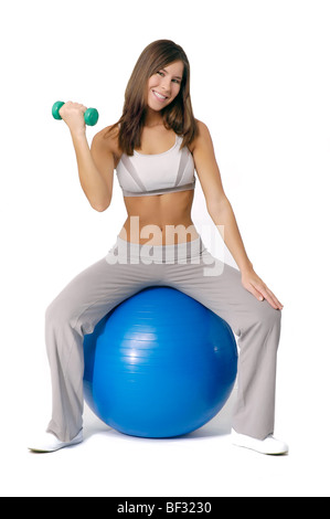 Attractive young woman working out using exercise ball. Stock Photo