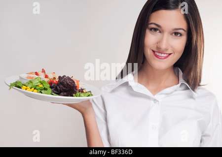 Portrait of a young woman holding a platter of shish kebabs Stock Photo
