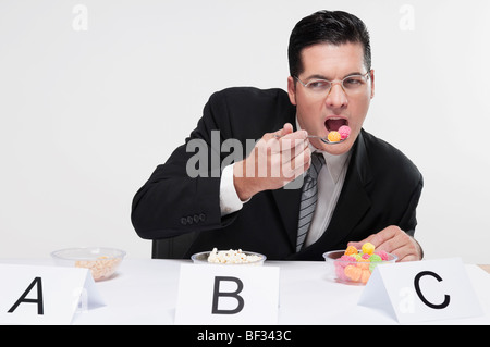 Businessman tasting food samples Stock Photo