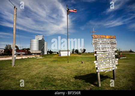 Entrance to McDonald, Kansas, pop. around 150. A billboard has the names of the Lions; the flag; a train and a grain elevator. Stock Photo