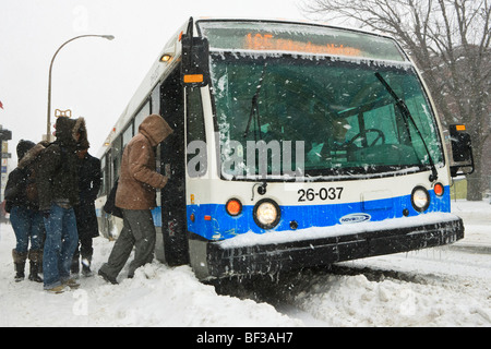 People boarding a bus during a winter snow storm on the plateau in Montreal. Stock Photo