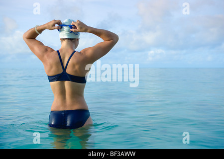 Woman preparing for swim in tropical sea Stock Photo