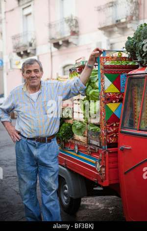 fruit vendor next to his ape-transporter Stock Photo