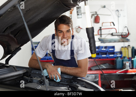 mechanic leaning on bonnet Stock Photo