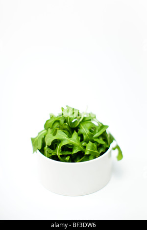 Bowl of rocket against a white background Stock Photo