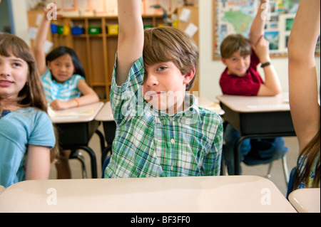 Students raising hands in class Stock Photo