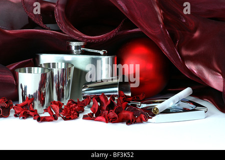 still life in crimson tints with shpere, flask, steell cups, colored dried plants, cigarette,  drapery and other objects Stock Photo