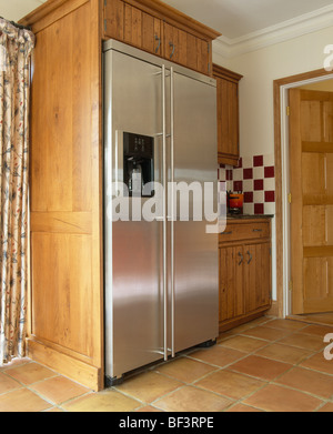 Large stainless steel American-style fridge freezer in fitted unit in traditional kitchen Stock Photo