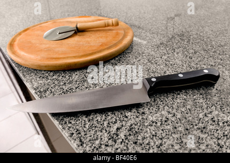 Kitchen knife with a pizza cutter on a cutting board Stock Photo